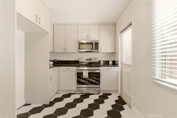 Completely reimagined, the kitchen features custom cabinetry, quartz countertops, stainless steel appliances, and modern finishes.