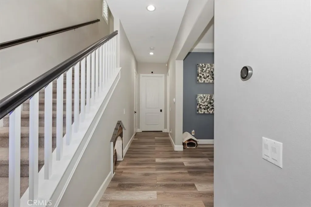 Hallway with view of pet room under stairs