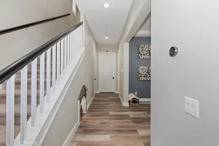 Hallway with view of pet room under stairs