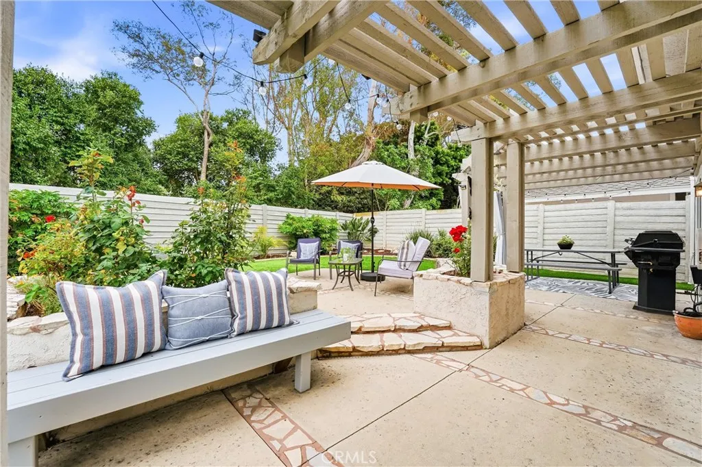 Raised planter beds with mature flowers, seated benches and a pergola create an outdoor area you will want to linger in.
