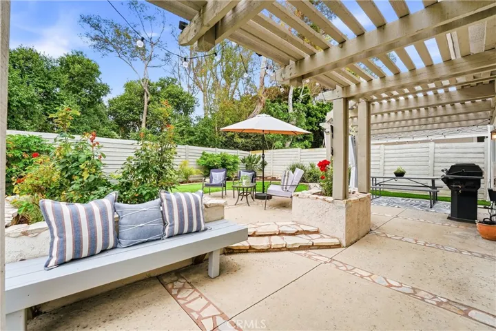 Raised planter beds with mature flowers, seated benches and a pergola create an outdoor area you will want to linger in.