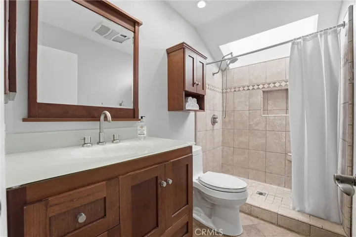 Walk in shower with shaker style cabinetry in this primary bath