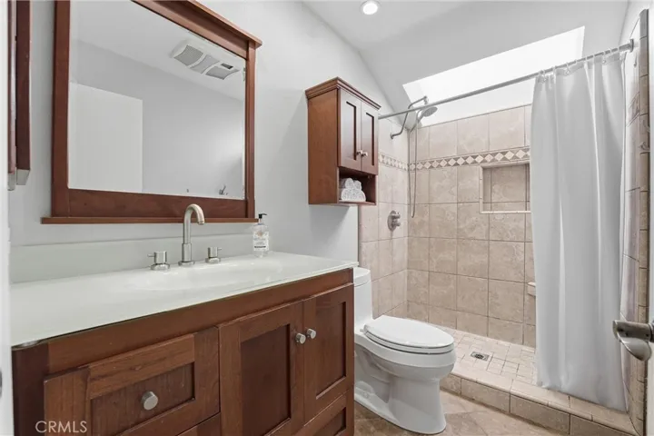 Walk in shower with shaker style cabinetry in this primary bath
