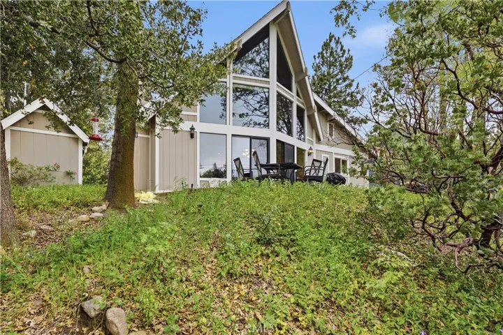 Welcome home! Your perfect mountain retreat featuring a grand floor-to-ceiling glass wall, cozy stone fireplace, and deeded Lake Rights.