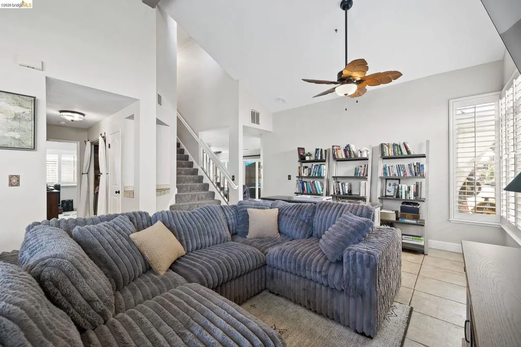 Open-concept living area with high ceilings, recessed lighting, and tile flooring