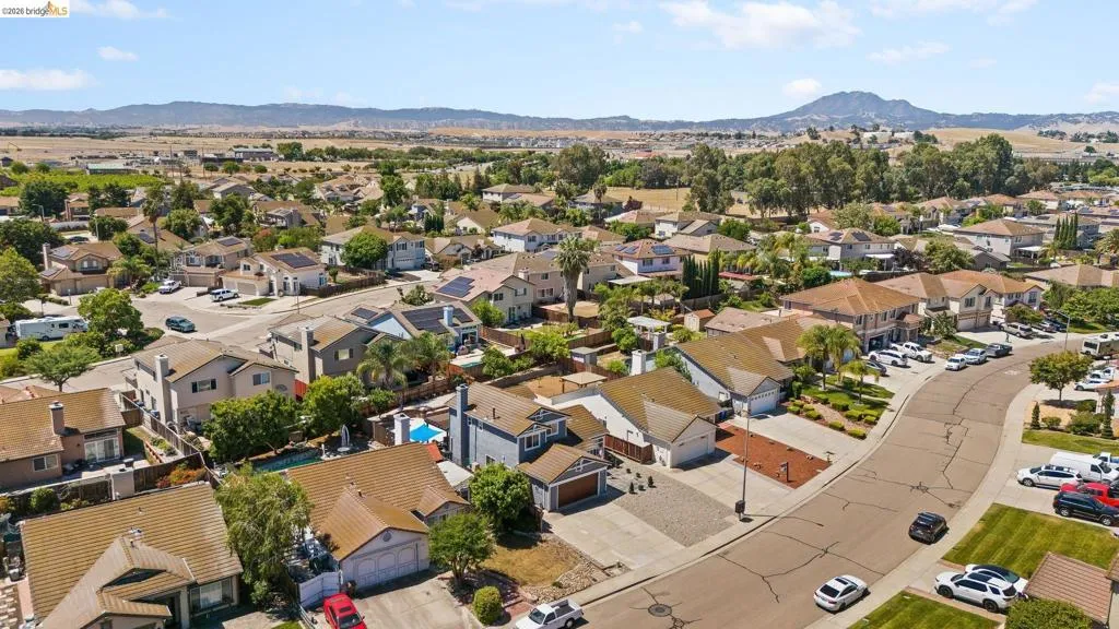 Aerial perspective showcasing a residential neighborhood with single-family homes, many featuring solar panel installations on their rooftops