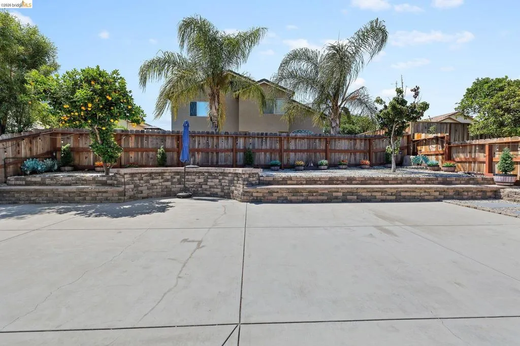Expansive concrete patio with tiered retaining walls