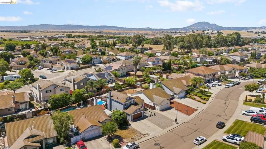 Aerial perspective showcasing a residential neighborhood with single-family homes, many featuring solar panel installations on their rooftops