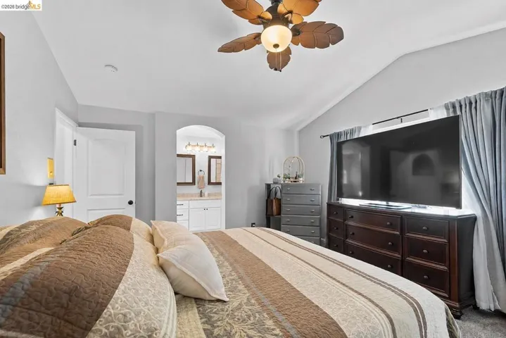 Spacious bedroom with vaulted ceiling and a ceiling fan