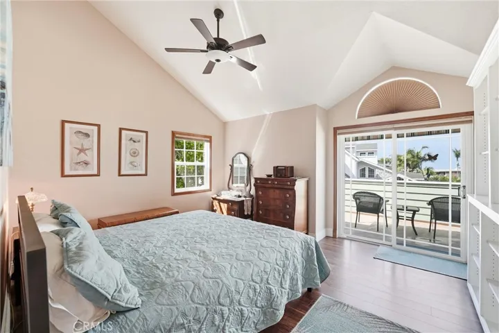 Spacious primary bedroom features vaulted ceilings, abundant natural light, and direct access to a private balcony. The airy design creates a peaceful retreat at the end of the day.