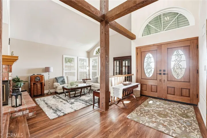 Elegant double entry doors open to a spacious living room with soaring ceilings, abundant natural light, and timeless architectural details.