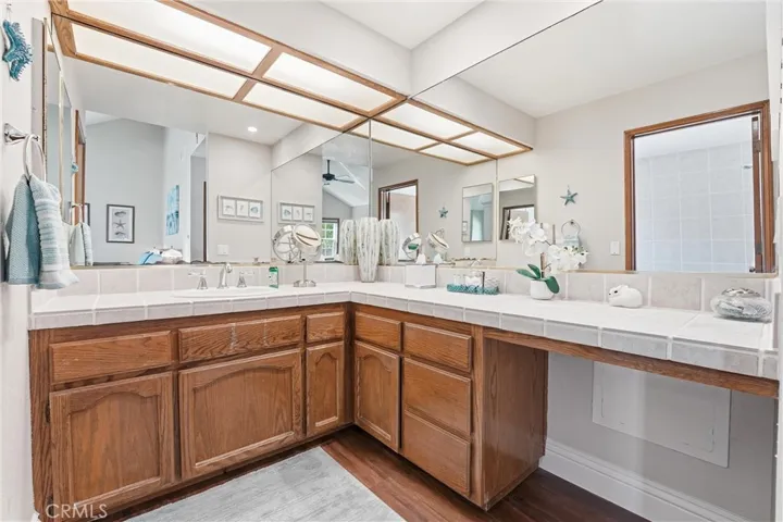 Primary bathroom offers an expansive vanity with ample counter space and oversized mirrors. The bright, functional layout is ideal for daily routines.