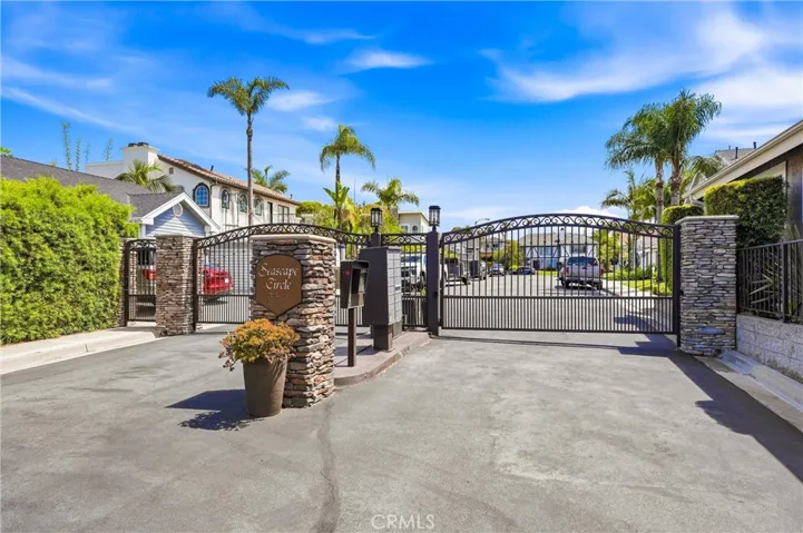 Gated entry to the Seascape Circle community welcomes residents with attractive stone accents, lush landscaping, and a well-maintained streetscape that enhances privacy and curb appeal.