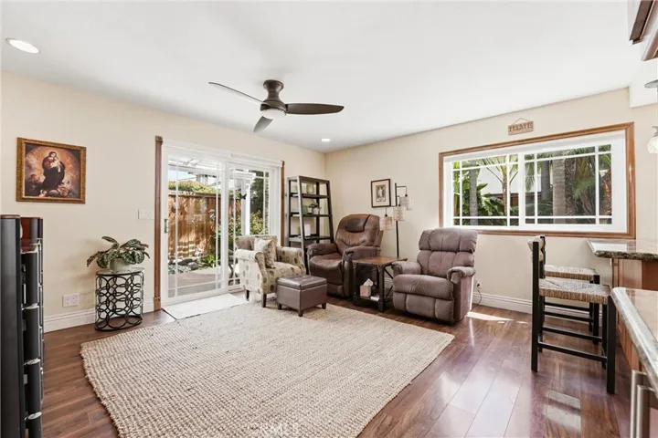 The adjacent family room offers a comfortable place to unwind, with large windows, backyard access, and plenty of space for relaxing or enjoying a movie night.