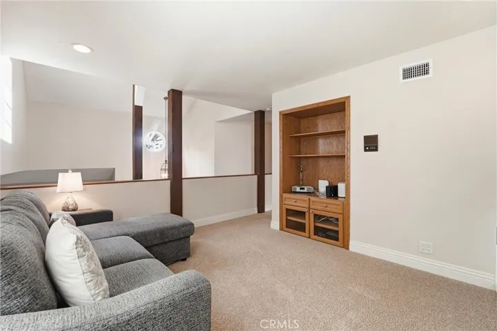 Alternate view of the loft showcases the open layout and built-in entertainment center. This flexible space adapts effortlessly to a variety of lifestyle needs.