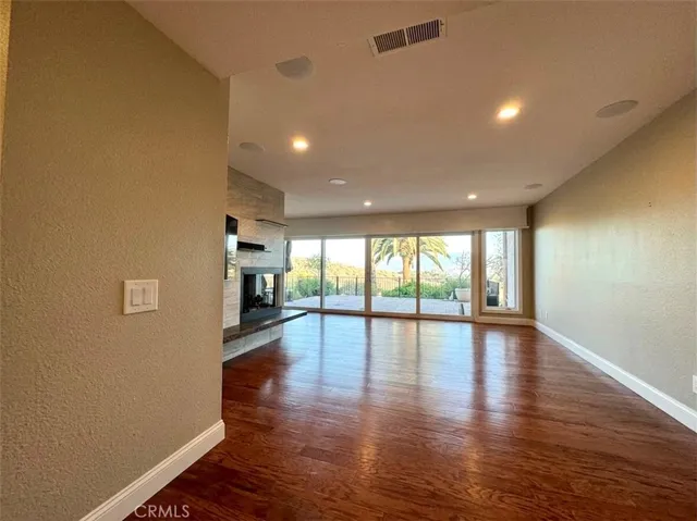 Living room with a fireplace. Pic altered to show space without furniture