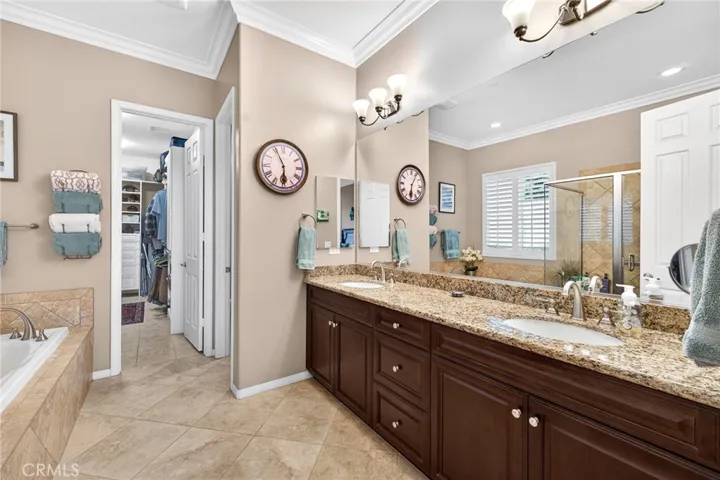 Double Sinks w/ Granite Countertops in Primary Bathroom and Huge Walk-in Closet is Organized with Self-Closing Cabinets, Drawers and Shelving