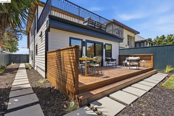 Multi-level wood deck featuring a slatted wood privacy screen and concrete paver pathways
