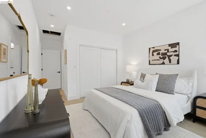 Bright interior space featuring recessed lighting, light wood-finish flooring, white walls, and a built-in closet with sliding doors