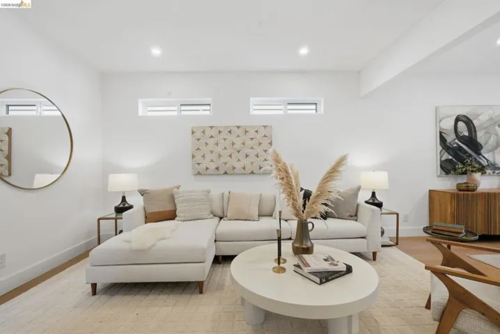 Bright living area featuring recessed lighting, high ceilings, transom windows, wood-finish flooring, and crisp white walls