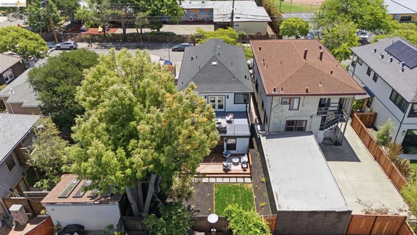 Multi-level decking with built-in seating, a manicured lawn area, and mature perimeter trees
