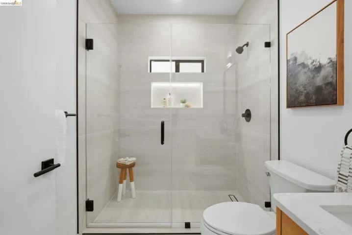 Glass-enclosed shower with tiled walls and flooring