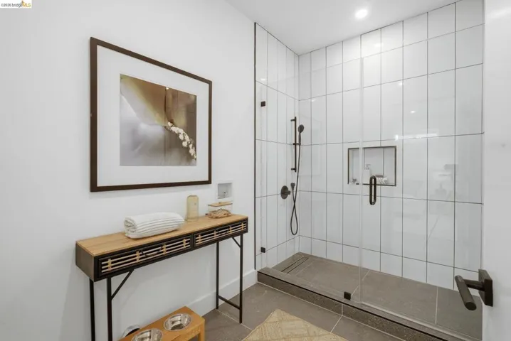 Walk-in shower with clear glass enclosure and matte black fixtures