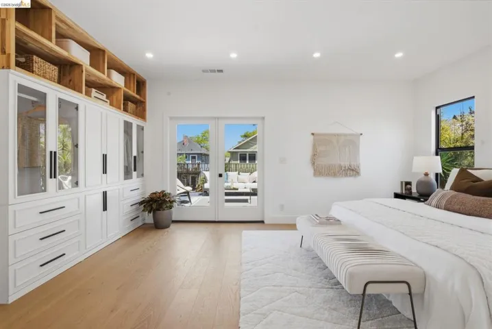 Spacious room featuring light wood-finish flooring, recessed lighting, and white walls