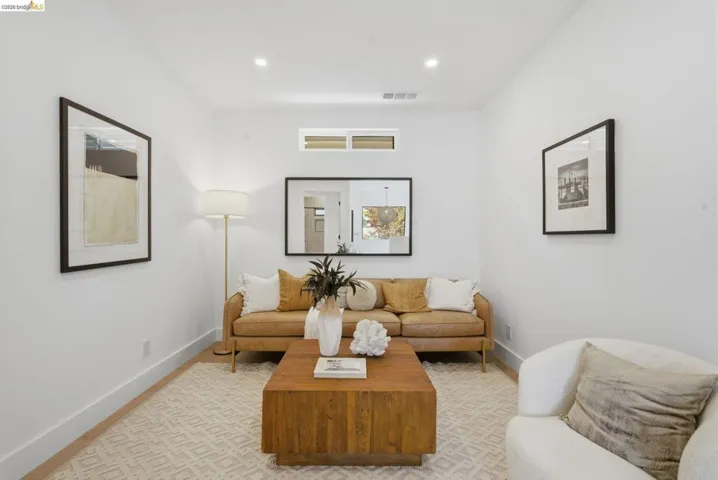Bright living area featuring recessed lighting, a high transom window, and wood-finish flooring
