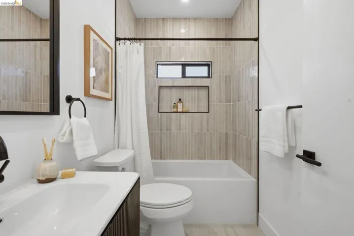 Bathroom featuring vertical subway tile shower surround, integrated shower niche, and a bathtub with a window