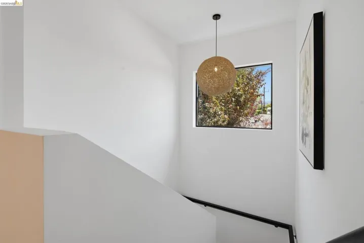 Stairwell featuring a contemporary spherical pendant light, black-framed window, and a black handrail
