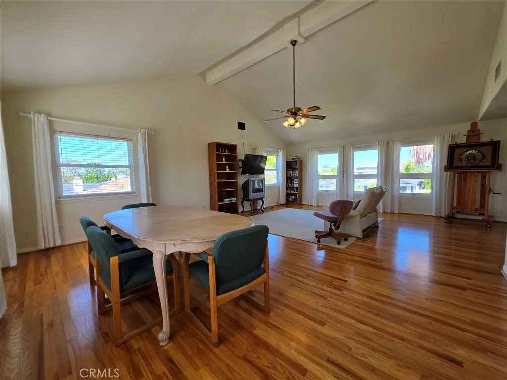 Vaulted bonus room with ceiling fan and 3 walls of windows