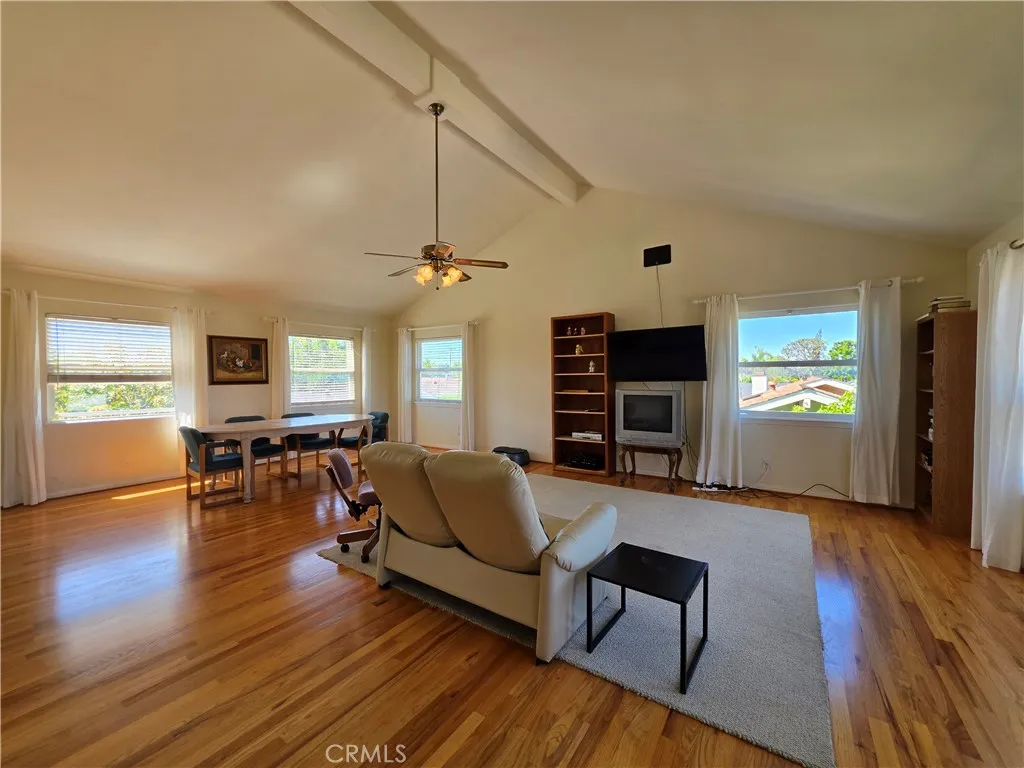 Upstairs vaulted loft/bonus room with hardwood floors