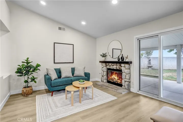 The family room offers a cozy fireplace, updated flooring, and direct access to the covered patio and backyard.