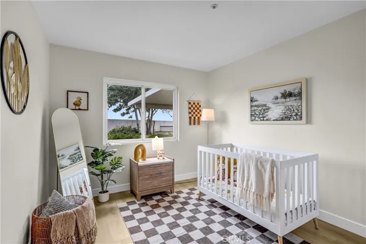 This secondary bedroom is sweet and bright, with updated flooring and a neutral design that works beautifully as a nursery or bedroom.