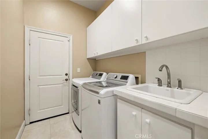 Laundry room with wash sink and access to 4-car garage