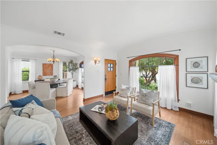 Living room and dining room connect through a period archway that mimics the front window shape.