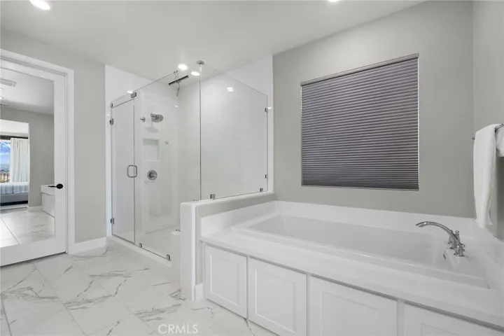 Primary bath soaking tub, walk in shower, and expansive walk-in closet