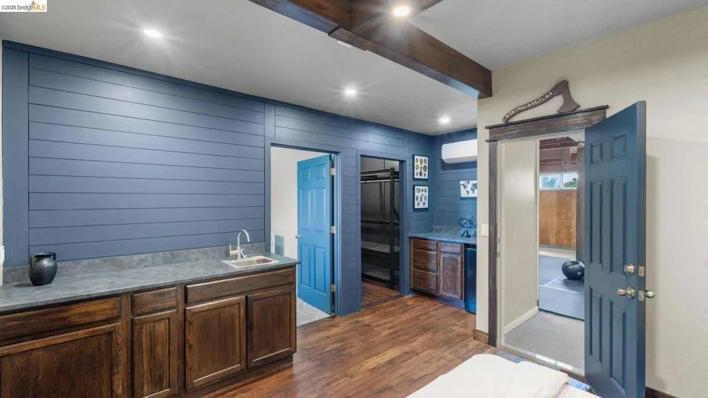 Entertainment space featuring wood-finish flooring, exposed ceiling beams, and recessed lighting