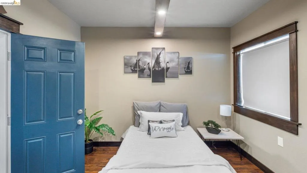 Wood-finish flooring throughout, complemented by a bold blue six-panel door