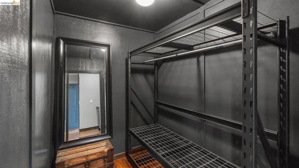 Dedicated storage space featuring a metal shelving system with an integrated hanging rod and durable metal grates