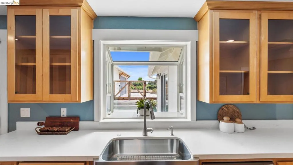 Kitchen sink with a stainless steel basin, a modern faucet, and light-toned countertops