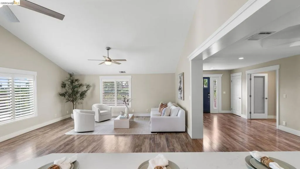 Vaulted ceilings feature a ceiling fan and recessed lighting, enhancing the spacious living area
