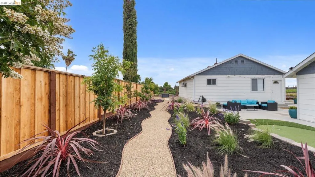 Expansive outdoor space featuring a winding gravel pathway bordered by landscaped beds