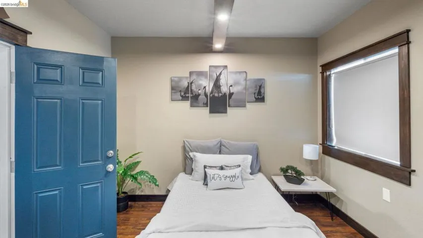 Wood-finish flooring throughout, complemented by a bold blue six-panel door