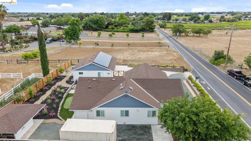 Aerial perspective showcasing the residential structures, extensive land, and adjacent roadway