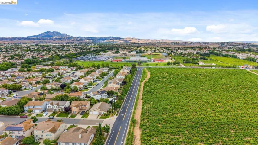 Expansive aerial perspective showcasing a residential development bordering agricultural land