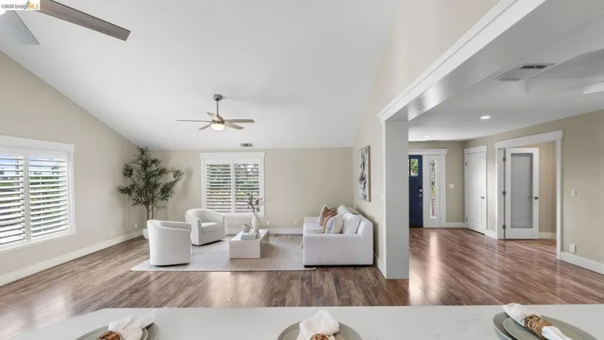 Vaulted ceilings feature a ceiling fan and recessed lighting, enhancing the spacious living area