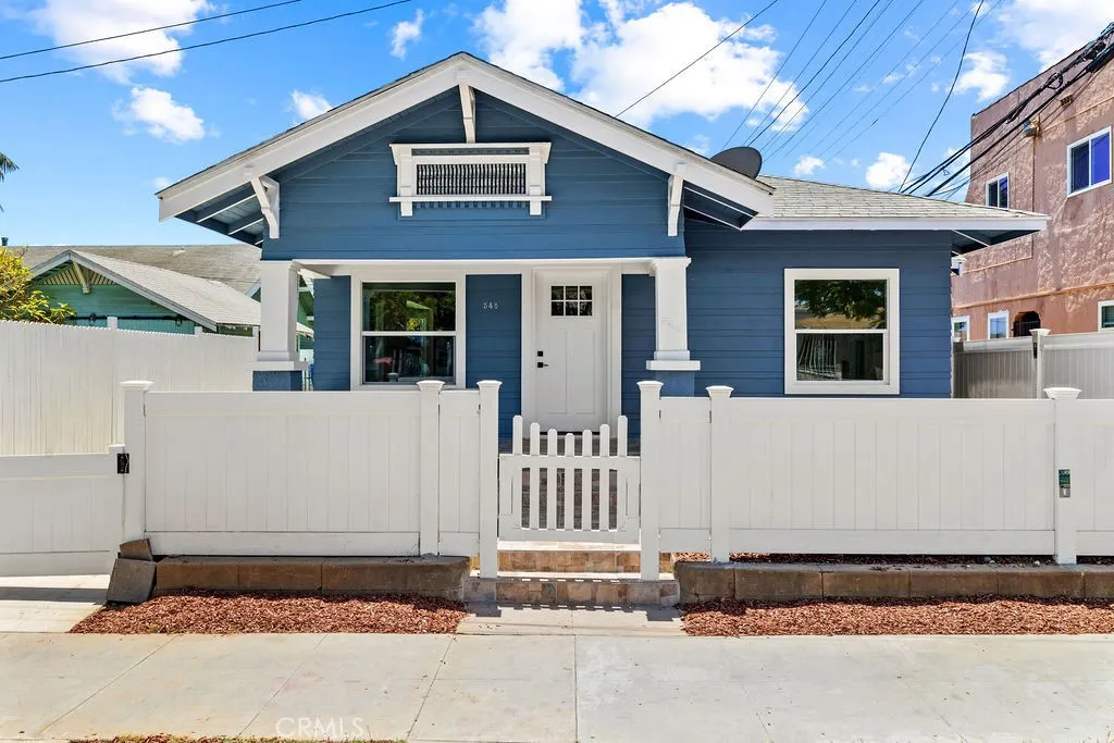 Revived single-story Craftsman showcasing preserved architectural character, fresh exterior finishes, and vinyl privacy fencing.