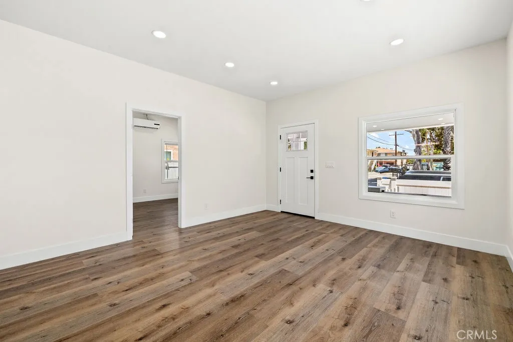 Spacious living area with updated flooring, recessed lighting, and abundant natural light.